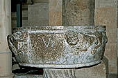 The cathedral of Cefal - Baptismal font (sec. XII) of dark marble and decorated with lions in bas-reliefs. 