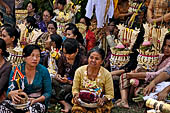 Cremation ceremony - The villagers line up, each with something to carry: holy water, ritual accessories, pyramids of food offerings piled high on their heads.