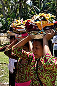 Cremation ceremony - The villagers line up, each with something to carry: holy water, ritual accessories, pyramids of food offerings piled high on their heads.