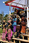 Cremation ceremony - Family members then passes ritual items up to be placed on the coffin. 