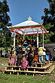 Cremation ceremony - Family members then passes ritual items up to be placed on the coffin. 