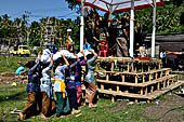 Cremation ceremony - Family members then passes ritual items up to be placed on the coffin. 