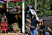 Cremation ceremony - Family members then passes ritual items up to be placed on the coffin. 