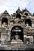 Borobudur - Buddha statues set in its own niche and pinnacles atop the balustrades of the lower four terraces.