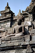 Borobudur - Buddha statues set in its own niche and pinnacles atop the balustrades of the lower four terraces.