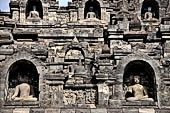 Borobudur - Buddha statues set in its own niche and pinnacles atop the balustrades of the lower four terraces.