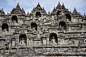 Borobudur - Buddha statues set in its own niche and pinnacles atop the balustrades of the lower four terraces.