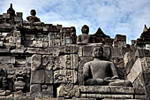 Borobudur - Buddha statues set in its own niche and pinnacles atop the balustrades of the lower four terraces. 