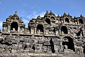 Borobudur - Buddha statues set in its own niche and pinnacles atop the balustrades of the lower four terraces.