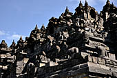 Borobudur - Buddha statues set in its own niche and pinnacles atop the balustrades of the lower four terraces.