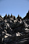 Borobudur - Buddha statues set in its own niche and pinnacles atop the balustrades of the lower four terraces.