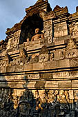 Borobudur - Buddha statues set in its own niche and pinnacles atop the balustrades of the lower four terraces. 