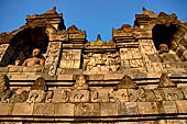 Borobudur - Buddha statues set in its own niche and pinnacles atop the balustrades of the lower four terraces.