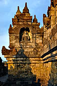 Borobudur - Buddha statues set in its own niche and pinnacles atop the balustrades of the lower four terraces. 