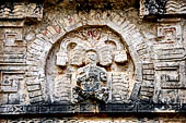 Chichen Itza - The Monjas (Nunnery) palace complex. Eastern patio with the eastern facade of the Nunnery. The frieze above the entrance of a seated figure of a dignitary inside a niche of arched feathers.