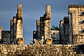 Chichen Itza - The temple of the Warriors. The upper esplanade on which the upper temple is built. In front the Chak-mool statue in between two magnificent pillars in the form of serpents.