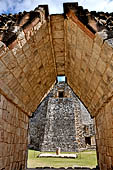 Uxmal - The west face of the  Magician Pyramid (el Adivino) seen from a corbelled vault of the Quadrangle of the Birds (Cuadrangulo de los Pajaros). 