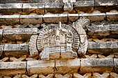 Uxmal - The Nunnery Quadrangle. The Eastern building. Detail of the trapezoidal frieze of the facade showing a owl head.