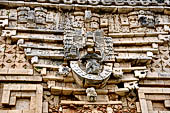 Uxmal - Palace of the Governor, front (East) facade. Detail of the frieze over the main doorway representing Lord Chaak against a tier of 7 serpents.