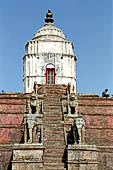 Bhaktapur - Durbar Square - Fasidega Temple (Shiva) on the eastern esplanade of the square, a white sikkara  on top of a platform with stairway flanked by cows and elephants. 