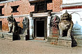 Bhaktapur - Durbar Square - Big lion statue of the entrance of the West wing of the Real Palace (now an art gallery) in between the  stone images of Hanuman and Narsingha.