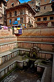 Bhaktapur - Golmadhi Square, where there is a deep hiti and the small three tiered temple dedicated to Golmadhi Ganesh and, nearby, a white chaitya.