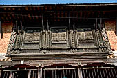 Changu Narayan - detail of the carved wooden windows of the pilgrims rest houses that surround the temple courtyard. 