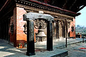 Gokarna Mahadev - South side of the temple with in front a stone torana holding a bronze bell.