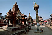 Patan Durbar Square - sikkara temple dedicated to Narsingha, in front the column with on top the statue of Yoganarendra Malla. 