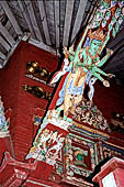 Patan - South of Durbar Square, the temple of Rato Machhendra Nath. The roof struts depict Avalokiteswara standing above figures being tortured in hell. 