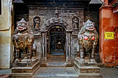 Patan  - The Golden Temple, two stone black lions guard the temple entrance.