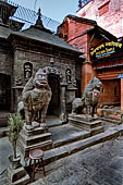 Patan  - The Golden Temple, two stone black lions guard the temple entrance. 