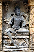 Hirapur - Sixtyfour Yoginis Temple, eastern niche of the mandapa south wall, ten armed Bhairava with erected penis holding a damaru, on a corpse, on the left a female attendant holding a shell and a scull cup.