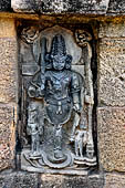 Hirapur - the Sixtyfour Yoginis Temple, southern niche of the east wall of the mandapa, a four armed figure of Ekapada Bairava with erected penis and standing on one leg. There are two mate attendants at the sides.