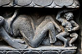 Hirapur - the Sixtyfour Yoginis Temple, eastern niche of the south wall of the mandapa, detail of the pedestal with a corpse which umbilical cord is being pulled. ON the right a female attendant.