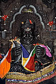 Orissa - Konarak - The Navagrahas architrave of the nine planets temple. Rahu (eclipse) the head of the dragon asura with a gruesome appearance and holding two moon crescents. 