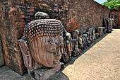 Ratnagiri - The main monastery. Loose stone sculptures lined up in the courtyard 