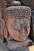 Ratnagiri - The courtyard of the main monastery. Imposing head of Buddha Tathagata (8th c.) 