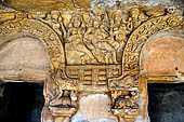 Udaigiri Cave 1 Rani Gumpha Queen's Cave - decorations of the three doorways of the veranda of the left wing of the ground floor. The second tableau (from left) a seated man between two women and  other two women holding offerings