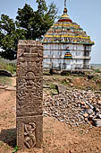 Udayagiri - Udayagiri II excavations. Detail of the carved stone stele. In the background the Hindu temple 