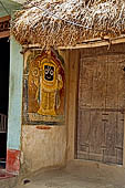 Orissa - Village visited along the road from Bhubaneswar to Puri. Paintings decorating house walls, Lord Jagannath. 