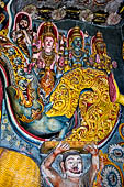 Aluvihara cave temples - Cave 1. Details of the dragon arch overhead of the Buddha with the face of the 'Kibihi' and Hindu gods.