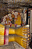 Dambulla cave temples - Cave 5, Devana Alut Viharaya (Second New Temple). On the wall behind Buddha feet the paintings of a dark Vishnu flanked by Kataragama with his peacock and Bandara (a local deity).