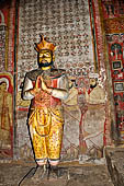 Dambulla cave temples - Cave 3, Maha Alut Viharaya (Great New Temple), statue of Kirti Sri Rajasinha the xviii century king with attendants painted onto the wall behind.