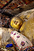 Dambulla cave temples - the narrow Cave 1, Devaraja Viharaya (Temple of the Lord of the Gods) is filled by a 14m-long sleeping Buddha, carved out of solid rock.