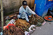 The market of Makale - stalls selling local produce including coffee, tobacco, buckets of live eels, piles of fresh and dried fish, and jugs of  'balok'