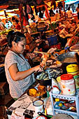 The market of Makale - stalls selling local produce including coffee, tobacco, buckets of live eels, piles of fresh and dried fish, and jugs of  'balok'